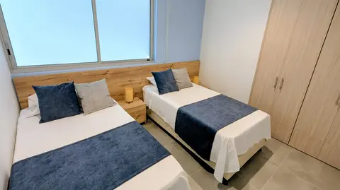 Spacious secondary bedroom with twin beds, perfect for families.